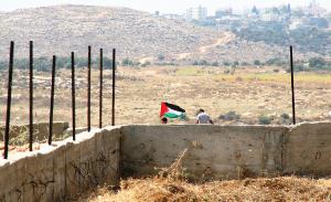 Ein Junge geht an einem Zaun mit palästinensischer Flagge vorbei. | Foto: Michael.Loedenthal/Flickr