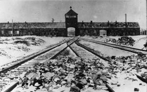 KZ Auschwitz, Einfahrt. Aufgenommen 1945, nach der Befreiung. Im Vordergrund von den Wachmannschaften zurückgelassene Ausrüstungsgegenstände