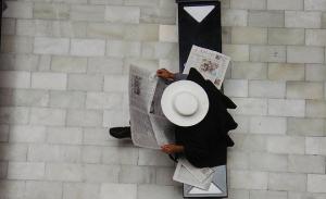 Ein Mann sitzt auf einer Bank in einem Museum in Ecuador und liest Zeitung | Foto: dfinnecy/Flickr