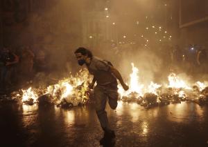 A demonstrator from the group called Black Bloc runs outside the Municipal Assembly during a protest supporting a teachers' strike in Rio de Janeiro October 7, 2013. The protest is to demand changes in the public state and municipal education system.