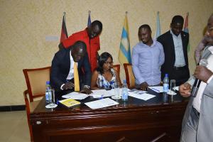 Chairperson of the NRM Youth League signing the communique denouncing Electoral Violence