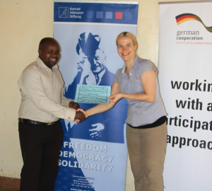 KAS staff, Antonie Hutter awarding a certificate of participation to the workshop on Conflict sensitive reporting to one of the participants Mr. Kipkulei.
