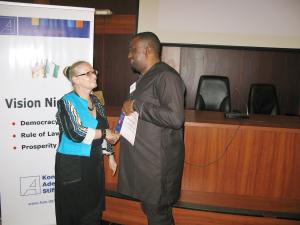 Die Direktorin der Konrad-Adenauer-Stiftung in Nigeria, Hildegard Behrendt-Kigozi, überreicht ein Teilnahmezertifikat an Joseph Bassey, stellvertretender Sprecher des Parlaments des Bundesstaates Cross River.