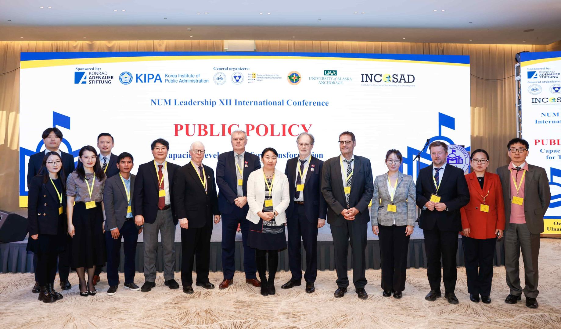 Banner für die NUM Leadership XII International Conference mit dem Titel 'PUBLIC POLICY'. Oben Logos von Sponsoren und Organisationen.