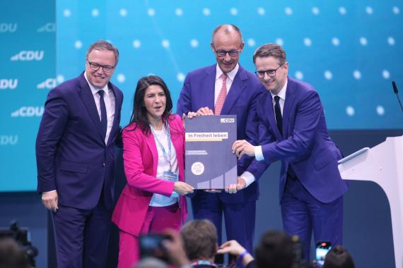 Mario Voigt, Serap Güler, Friedrich Merz und Carsten Linnemann mit dem frisch beschlossenen neuen CDU-Grundsatzprogramm auf dem Parteitag 2024