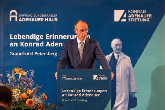 Friedrich März steht am Rednerpult und stützt sich daran ab