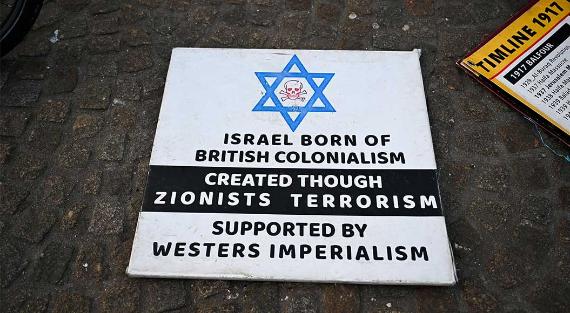 Auf dem Boden liegt ein Plakat mit einer Botschaft, die die Gründung Israels mit britischem Kolonialismus und zionistischem Terrorismus gleichsetzt, während einer Demonstration in Amsterdam, Niederlande, am 16. Februar 2025. Die Demonstranten versammelten sich, um gegen die Aussetzung syrischer Asylanträge zu protestieren und ihre Solidarität mit den palästinensischen Kämpfen zu bekunden.