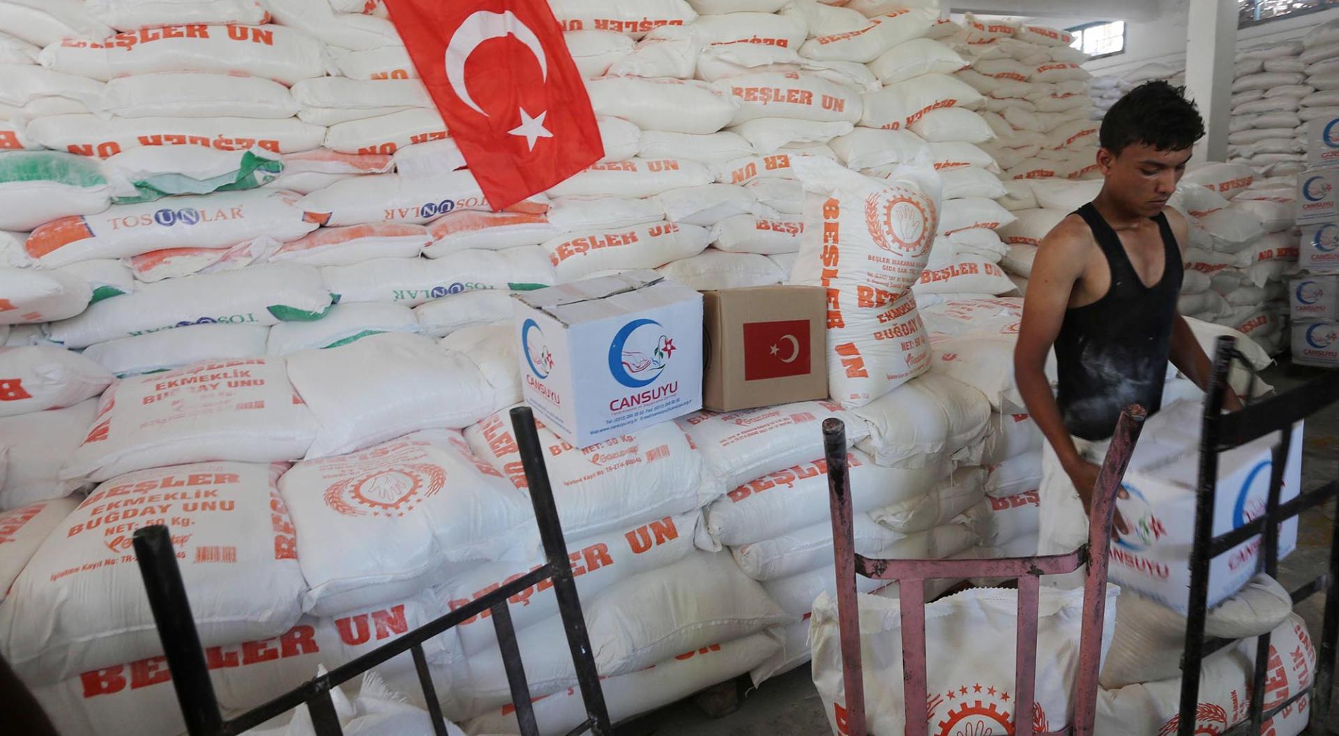 Palestinians receive Turkish aid at an aid distribution centre in Gaza city, on July 19, 2016. The aid, consisting of flour, sugar and rice, was allowed into the Palestinian territory via Israels Kerem Shalom crossing and will be stored in warehouses run by Gazas Social Affairs Ministry before being distributed to the strips neediest residents.