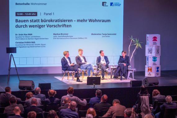Foto der Veranstaltung mit Blick auf das Podium und das Publikum