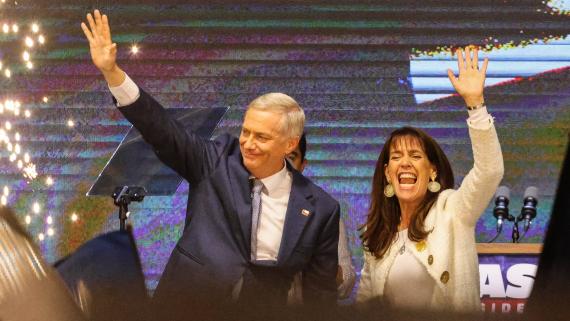 Jose Antonio Kast steht mit blauem Anzug auf der Bühne und streckt feierlich seinen rechten Arm zum Publikum.