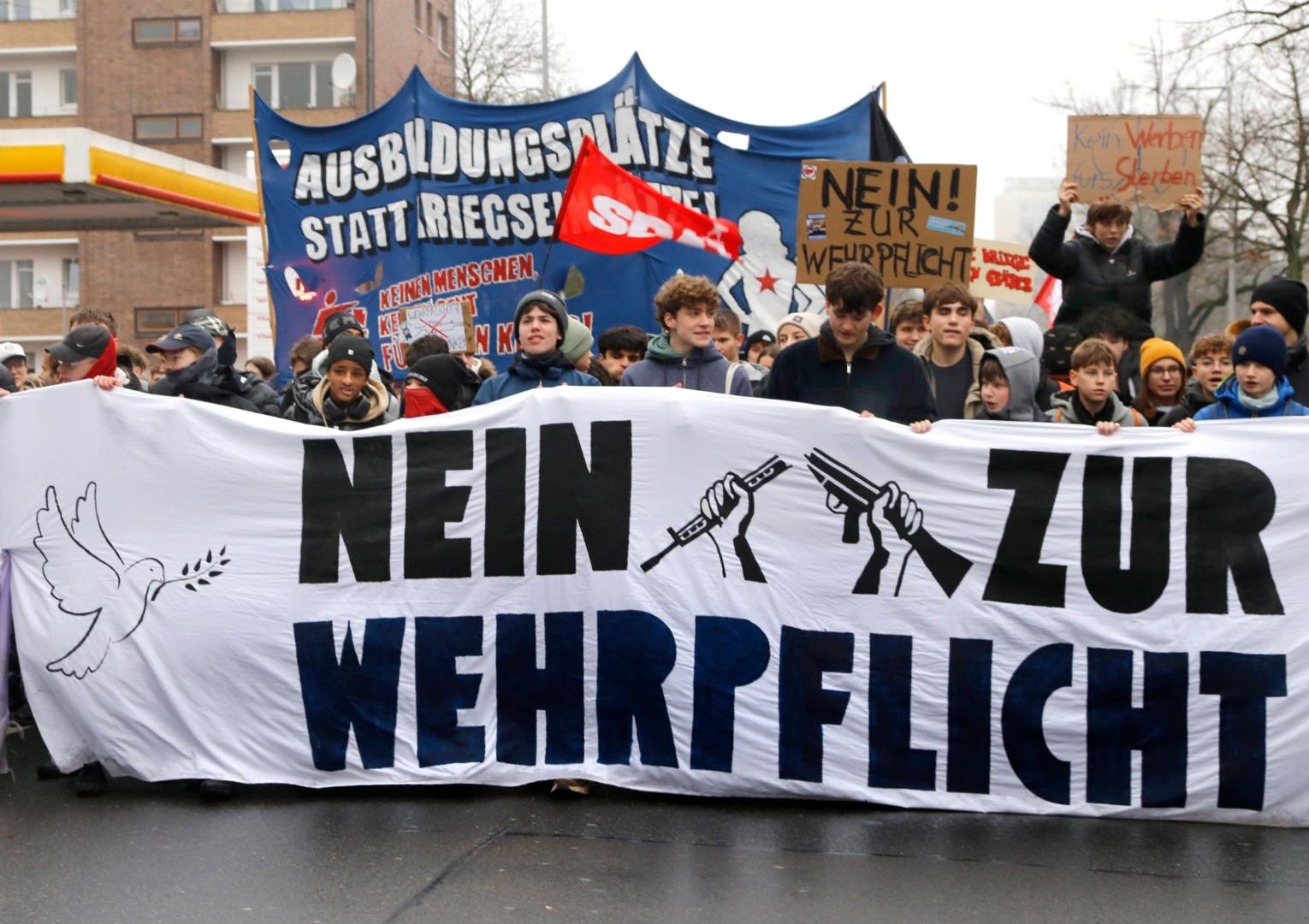 Jugendliche auf einer Demo gegen den Wehrdienst mit einem Banner mit der Aufschrift 