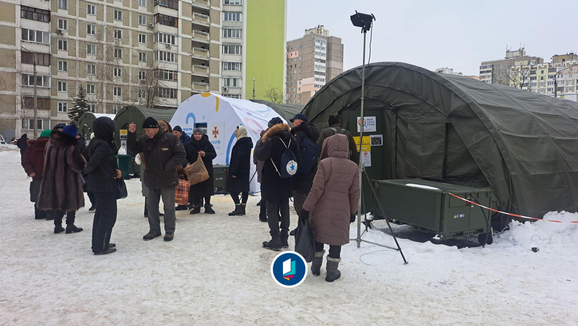 Kyiv im Februar 2026: Im Stadtteil Trojeschtschyna stehen Menschen während eines Luftalarms vor Wärmezelten und warten auf die Nachricht für die Entwarnung.