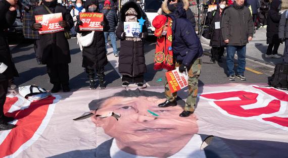 Mitglieder der Marine Corps Reserve Association zerreißen ein großes Banner mit dem Gesicht des dem Amt enthobenen Präsidenten Yoon Suk-yeol während einer Kundgebung, bei der seine Verhaftung gefordert wird, in Hannam-dong, Yongsan-gu, am 9. Januar 2025 in Seoul, Südkorea.