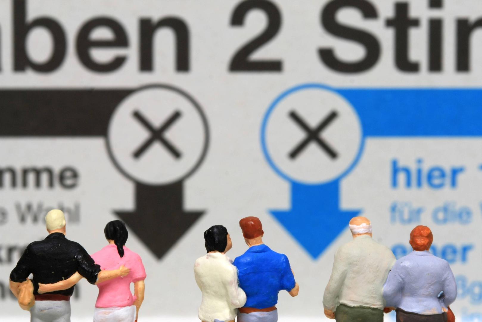 Miniatur Figuren stehen auf einem Stimmzettel