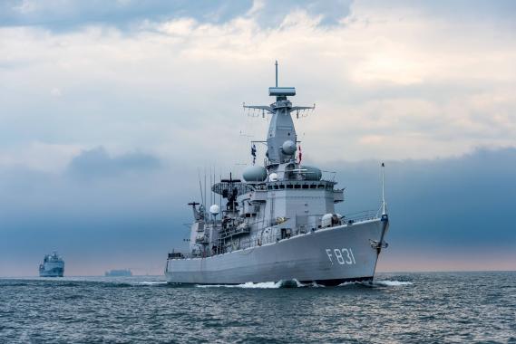 Kriegsschiff der Deutschen Marine mit der Kennung F831 fährt auf ruhiger See unter bewölktem Himmel