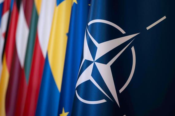 Nahaufnahme der NATO-Flagge mit weiteren unscharfen Flaggen im Hintergrund