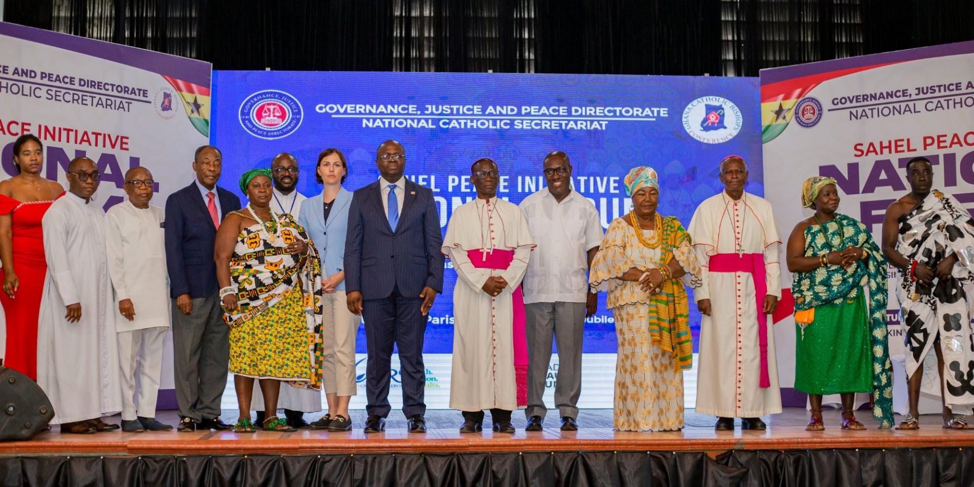 Group photo of political, religious and civil society representatives at a conference on the Sahel Peace Initiative in Ghana. Participants stand together on stage in front of an event banner.