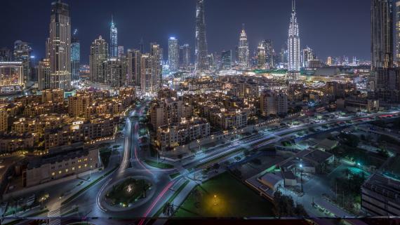 Aerial view of a roundabout circle road in Dubai downtown from above night timelapse. Dubai, United Arab Emirates.