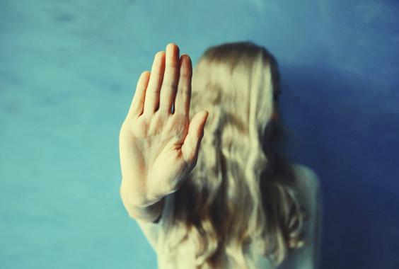 Verärgerte Frau zeigt Stoppschild mit Handfläche.