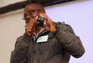 A delegate from Zimbabwe demonstrates the Chinese-made wind-up radio.